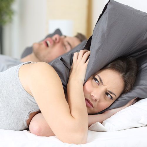 Woman trying to sleep through husband’s snoring