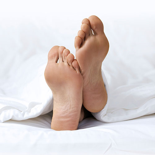 Man’s feet whilst asleep in bed